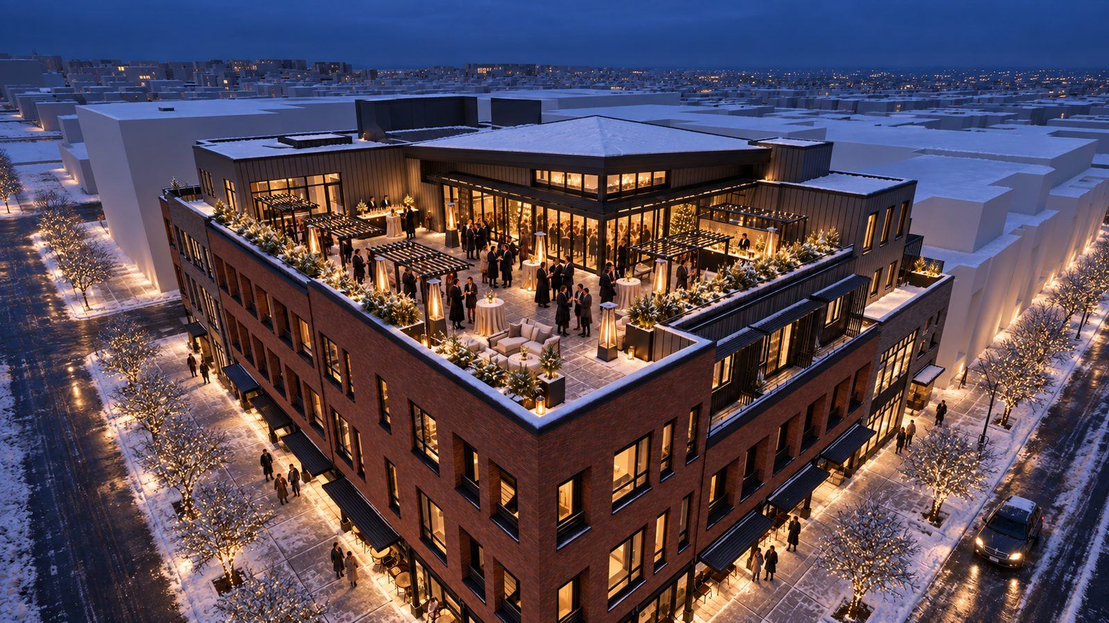 The Annex from above on a snowy winter evening, the VUE/boulder rooftop lit for a holiday reception, downtown Boulder glowing below.